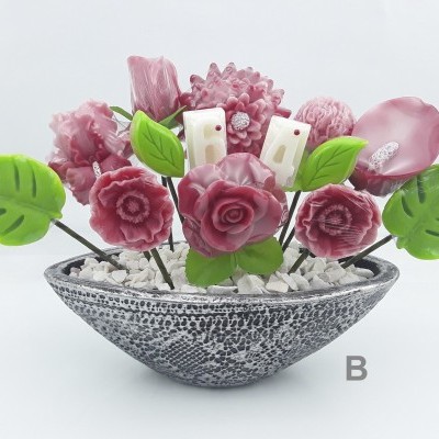 Arranjo artificial com flores rosas e folhas verdes em vaso grisáceo