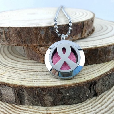 Colar prateado com fita rosa e fundo de feltro cor de rosa sobre discos de madeira