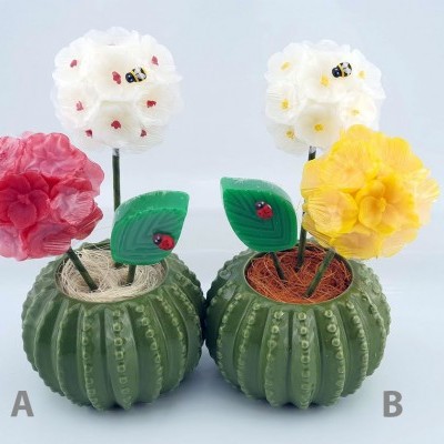 Dois arranjos florais em vasos verdes imitando cactos com flores coloridas e joaninhas