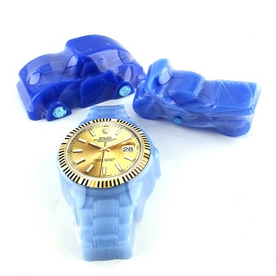 Relógio dourado com pulseira azul claro e dois carros de brinquedo azuis