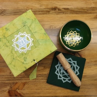 conjunto de tigela tibetana com almofada, pau de madeira e caixa verde sobre mesa de madeira