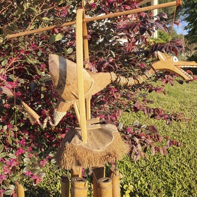 Escultura de dinossauro de madeira e fibras em jardim