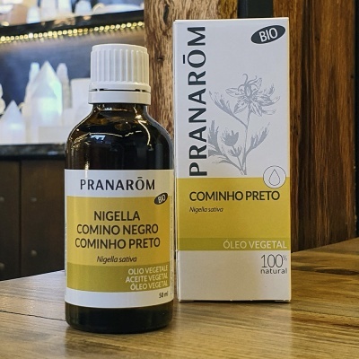 Frasco de óleo vegetal de cominho preto da PRANARÔM com embalagem ao fundo