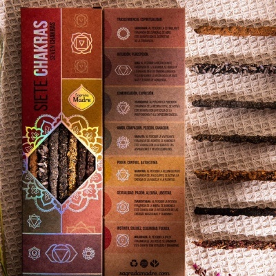 Caixa colorida de incenso Siete Chakras com sete varetas visíveis ao lado de tecido bege com franjas