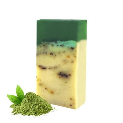 Sabonete em barra com camadas verdes e creme ao lado de pó verde