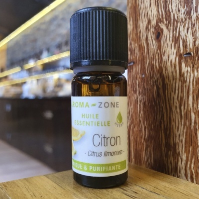 Frasco de óleo essencial de Citron da Aroma-Zone sobre superfície de madeira