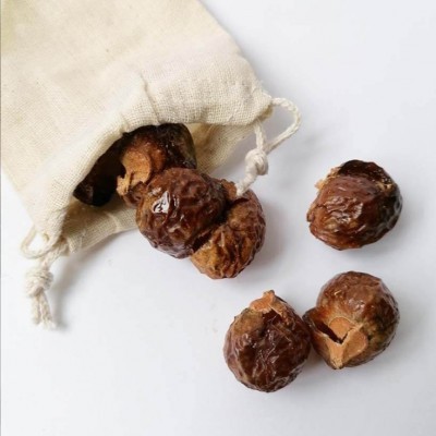 Frutos secos castanhos com textura rugosa dentro e fora de saco de tecido cru