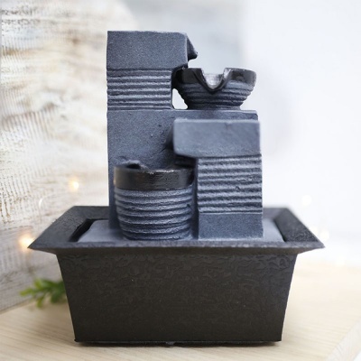 Fonte decorativa cinzenta com base preta em madeira clara