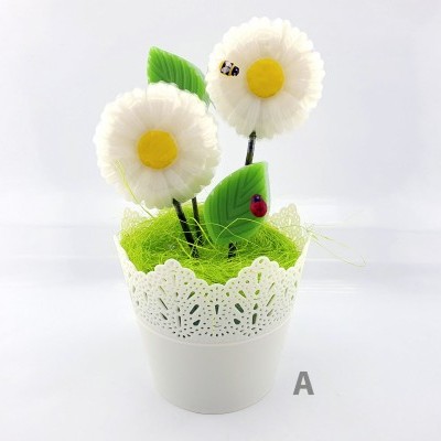 Arranjo decorativo com flores brancas e folhas verdes num vaso branco.