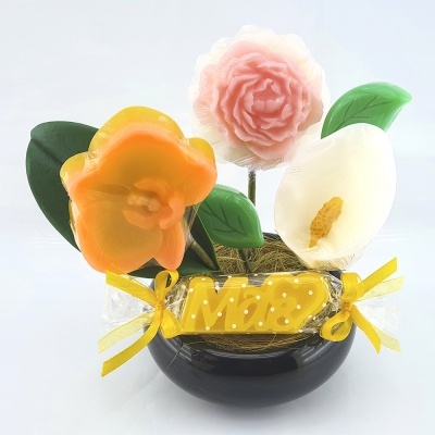 arranjo decorativo com flores de sabão coloridas, base preta e placa amarela com texto IMBOP