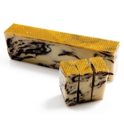 Barra de sabão marmoreado com topo amarelo texturizado e três pedaços cortados