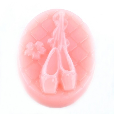 Sabonete oval cor-de-rosa com relevo de sapatilhas de balé e uma flor