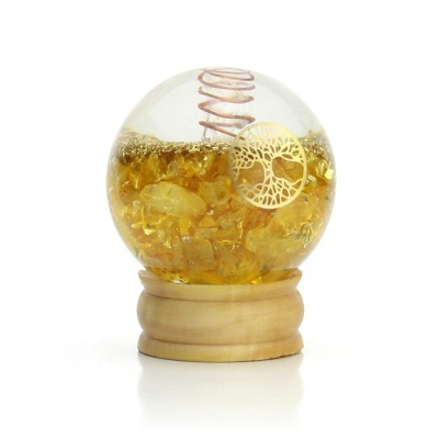 Globo de cristal com cristais amarelos e base de madeira