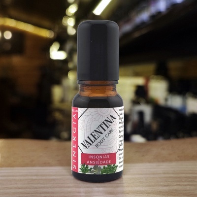 Frasco de vidro âmbar com tampa preta e rótulo branco com texto relacionado a insónias e ansiedade