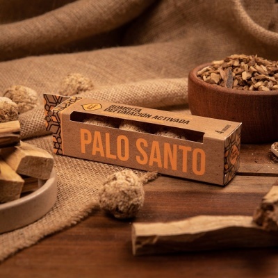 Embalagem de Palo Santo com pedaços de pau em mesa de madeira