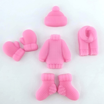 Conjunto de roupa de inverno em miniatura cor de rosa com gorro, cachecol, camisola, luvas e meias.