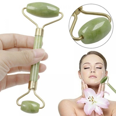 Rolo de massagem facial em pedra verde com detalhes metálicos dourados