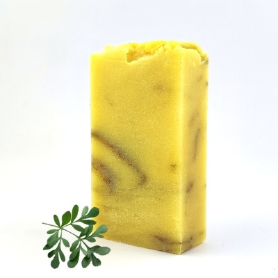 Sabonete amarelo com padrão marmoreado castanho e ramo verde