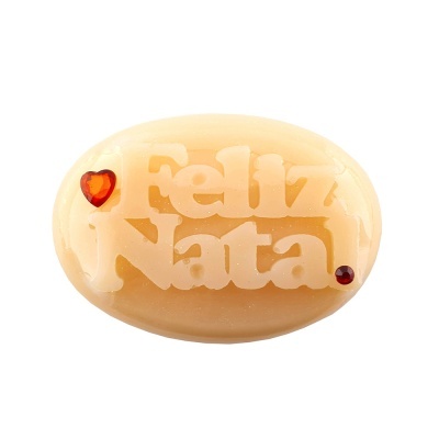 Sabonete oval creme com texto 'Feliz Natal' em relevo e decoração vermelha