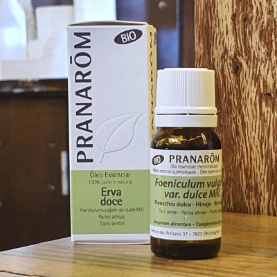 Frasco e caixa de óleo essencial Pranarôm Erva Doce bio sobre superfície de madeira