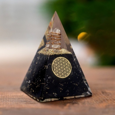 Piramide preta e dourada com espiral de cobre e símbolo circular dourado