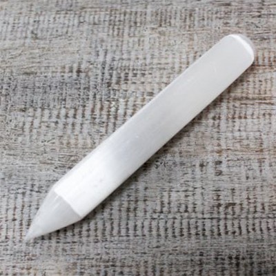 Caneta branca de ponta fina sobre superfície de tecido cinzento-bege