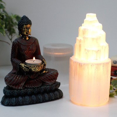 Figura de Buda com vela e lâmpada de sal iluminada