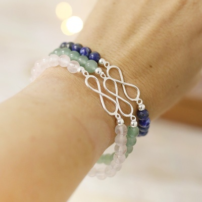 Pulseiras com contas coloridas e símbolo infinito prateado no pulso