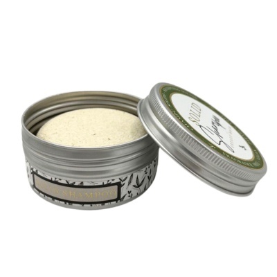 Pote metálico prateado com shampoo sólido bege e tampa com rótulo verde e branco