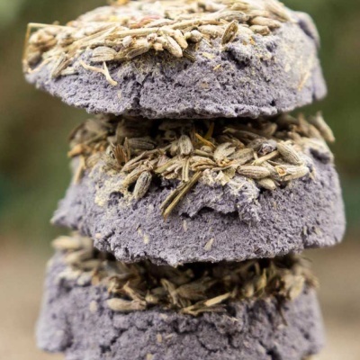 Sabonetes roxos empilhados com sementes secas por cima.