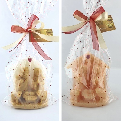 Figuras religiosas de barro embaladas em plástico com laço e etiqueta dourada