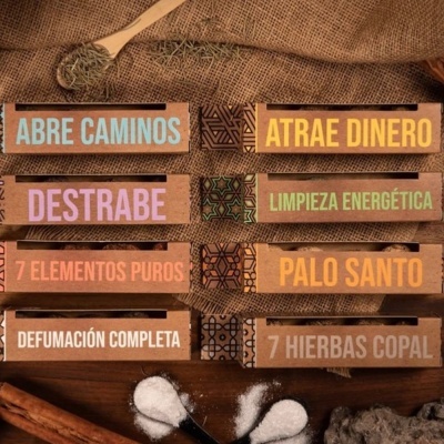 Caixas de incenso coloridas sobre tecido de estopa com pau de canela e colher de madeira