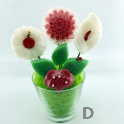 Flores decorativas coloridas em vaso transparente com enchimento verde