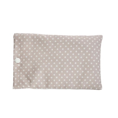 Almofada rosa claro com pontos brancos e botão branco num fundo branco