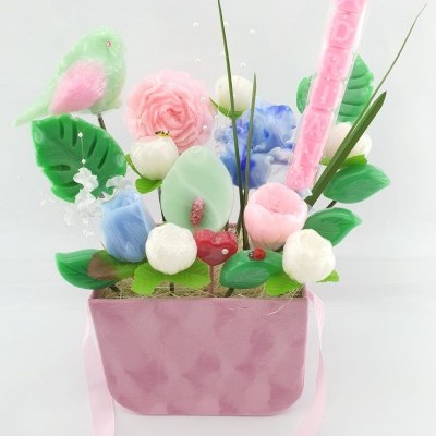 Arranjo decorativo com flores coloridas e placa rosa com texto Adoro-te