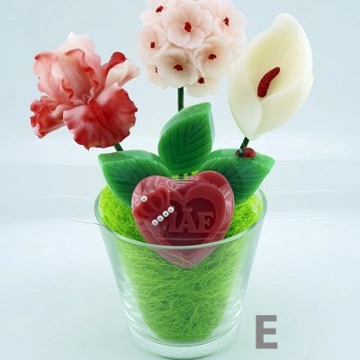 Arranjo decorativo com flores artificiais e coração vermelho com a palavra MAE num vaso de vidro
