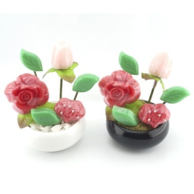 Flores decorativas artificiais vermelhas com folhas verdes em vasos preto e branco