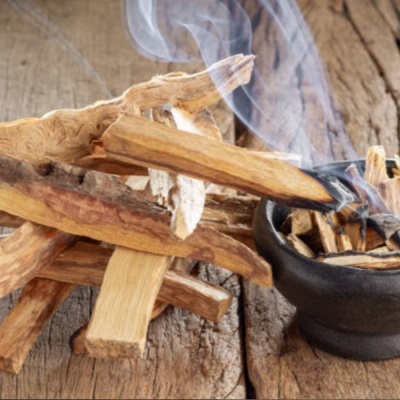 Pedaços de madeira empilhados com fumaça sobre superfície de madeira.