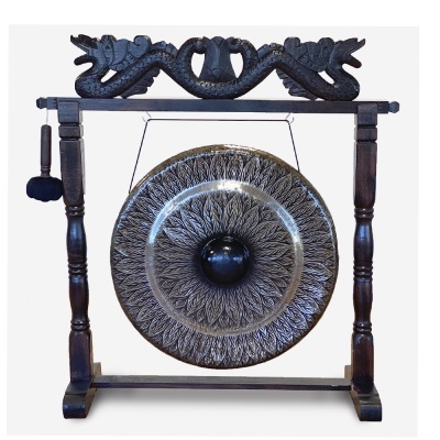 gongo musical de metal escuro com suporte de madeira entalhada