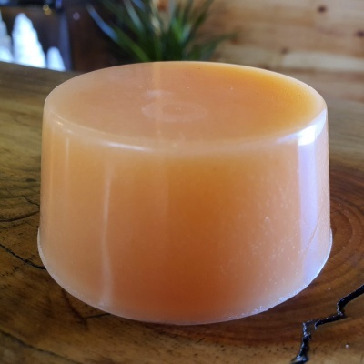 Sabonete redondo alaranjado sobre madeira rústica