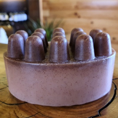 Sabonete rosa com protuberâncias em superfície de madeira