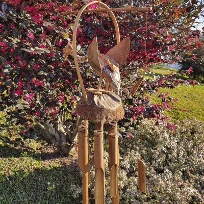 Sino dos ventos de bambu com figura de pássaro em madeira e folhas secas pendurado no exterior
