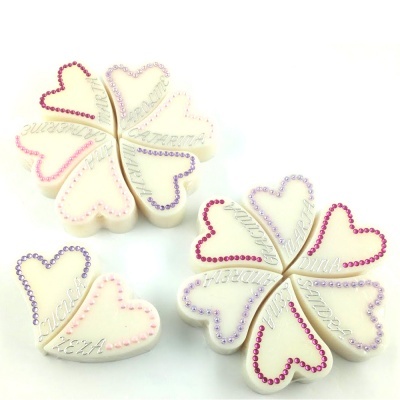 Biscoitos decorados em forma de corações e trevos de quatro folhas com glacê branco e cristais coloridos