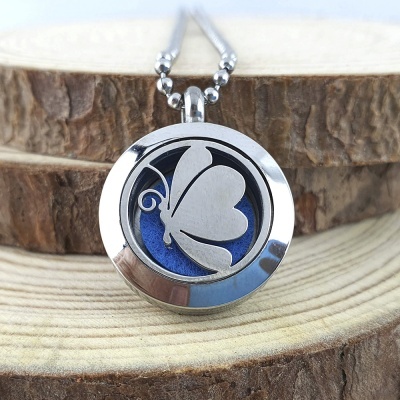 Colar prateado com pendente de borboleta e interior azul sobre madeira