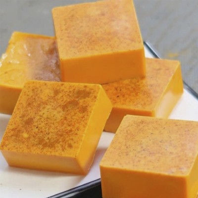 Cubos de bolo laranja com pó castanho em prato branco