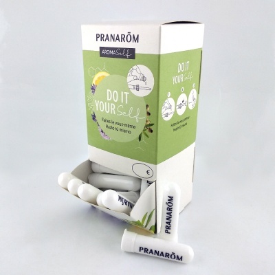 Embalagem branca e verde clara de ampolas de aroma PRANARÔM com texto e instruções ilustradas.