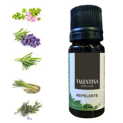 Frasco de óleo repelente Valentina Body Care com ervas frescas ao lado