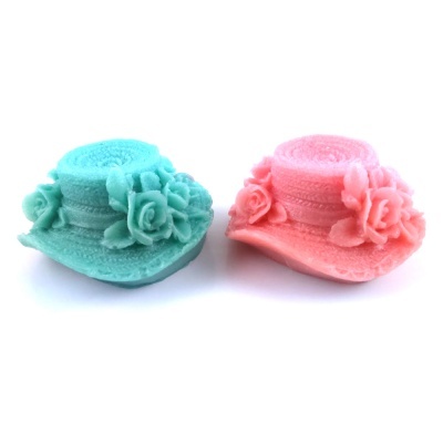 Dois chapéus decorativos pequenos azul e rosa com flores ao redor