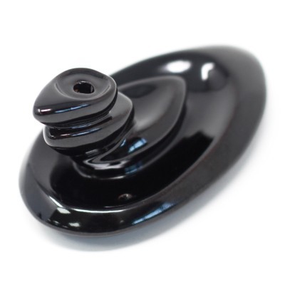 Peça de cerâmica preta com acabamento brilhante em fundo branco