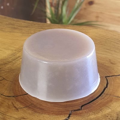 Sabonete transparente cilíndrico sobre superfície de madeira